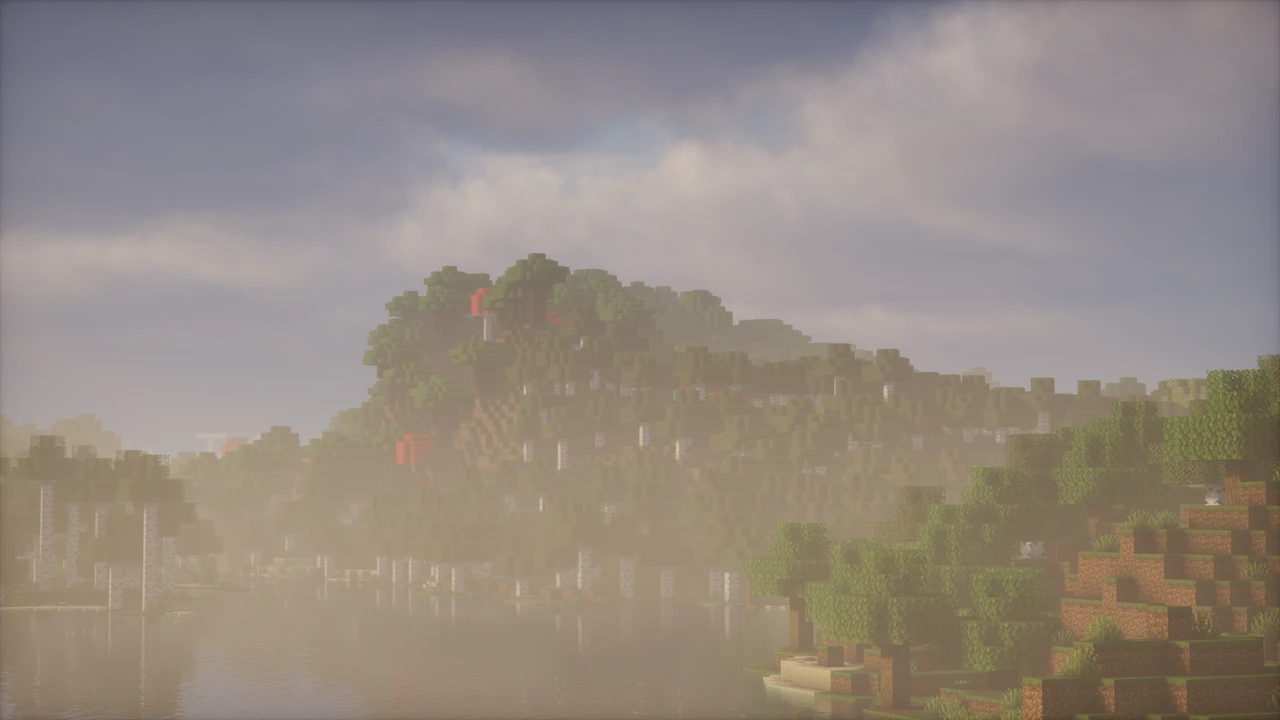 Birch-covered hill across a misty lake, with a grassy slope on the right